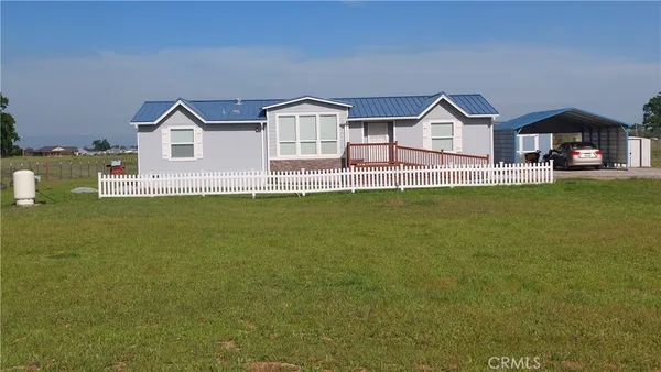 a view of a house with a small yard and wooden fence
