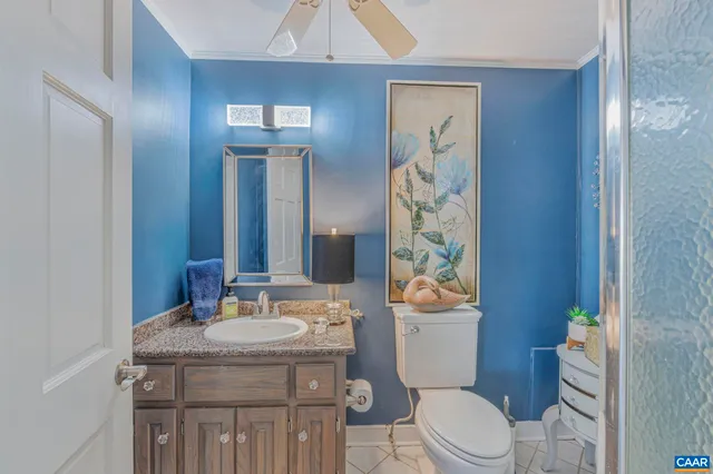 a bathroom with a granite countertop toilet a sink and a mirror