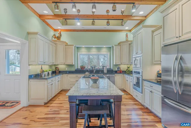 a kitchen with granite countertop a table chairs microwave and cabinets