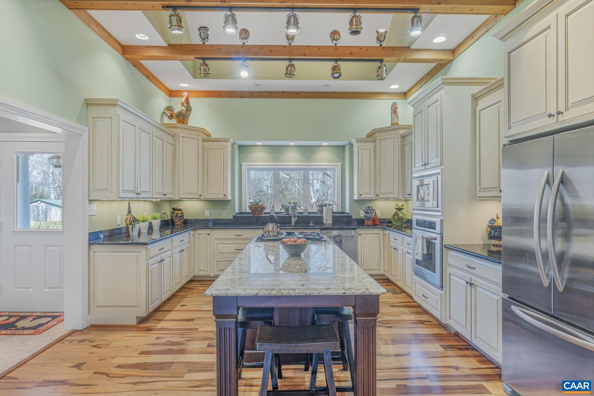 1353 Banton Shop Road Dillwyn, VA 23936 - Photo 6 of 57 a kitchen with granite countertop a table chairs microwave and cabinets