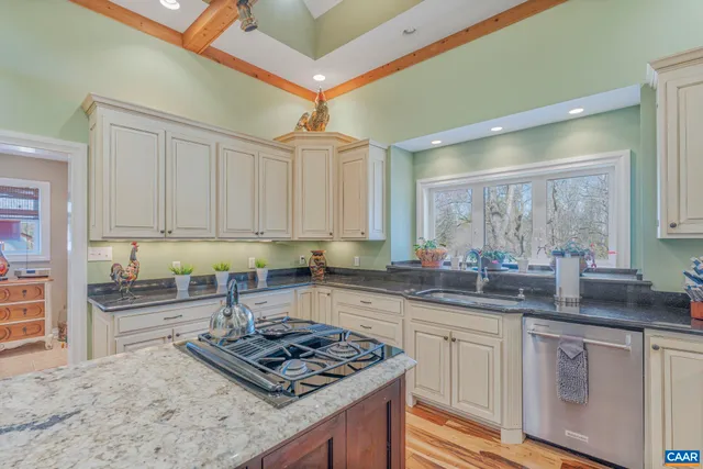 a kitchen with stainless steel appliances granite countertop a stove sink and cabinets
