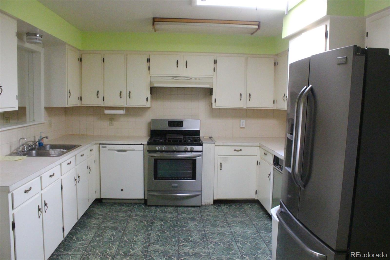 4935 Howell Street Golden, CO 80403 - Photo 24 of 34 a kitchen with white cabinets and stainless steel appliances