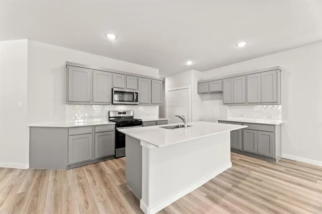 a kitchen with a sink stove top oven and refrigerator