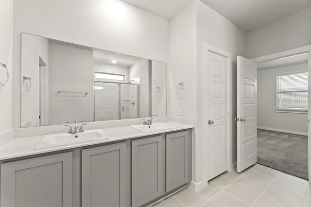 a bathroom with double sink and a mirror