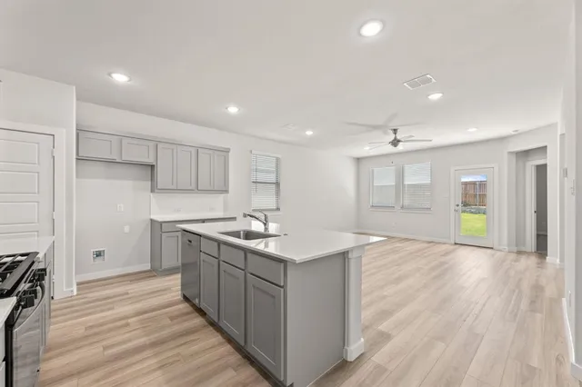 a kitchen with stove cabinets and wooden floor