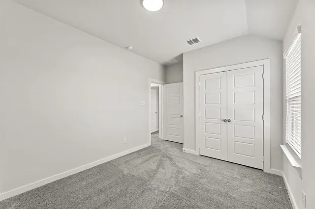 an empty room with windows and closet