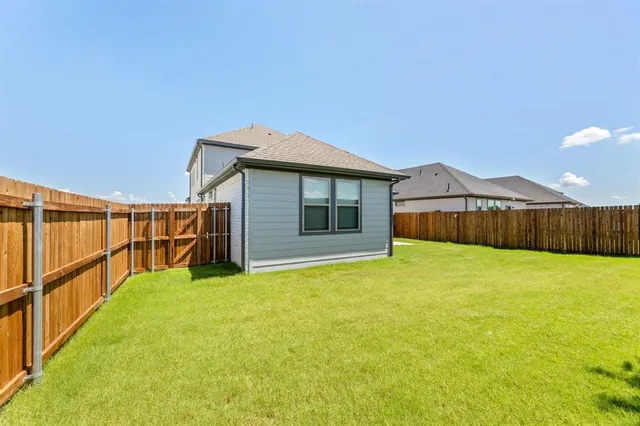 a view of an house with backyard and road