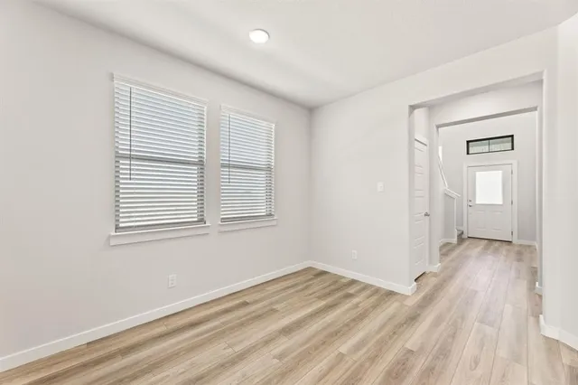 a view of a room with wooden floor and windows