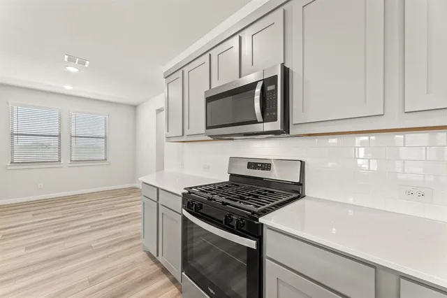 a kitchen with stainless steel appliances white cabinets and stove