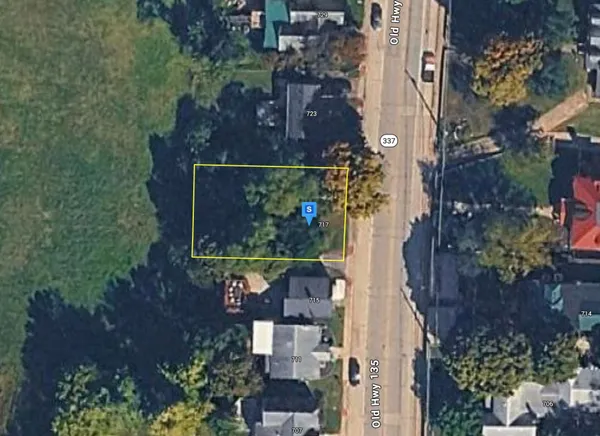 an aerial view of a house with a yard and large trees