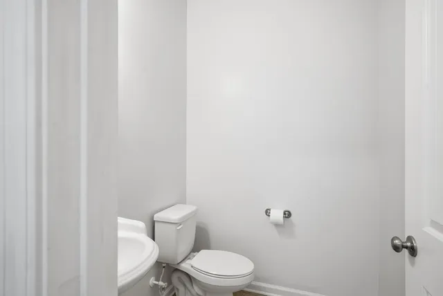a white toilet sitting next to a shower