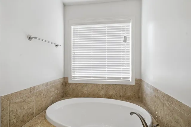 a bathroom with a bathtub and a window