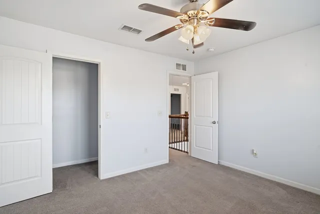 an empty room with fan and windows