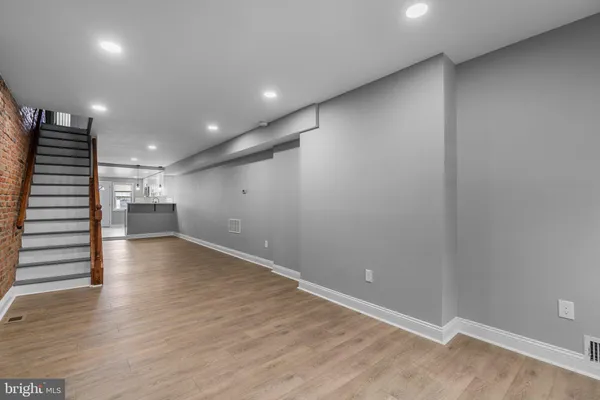 an empty room with wooden floor and entryway