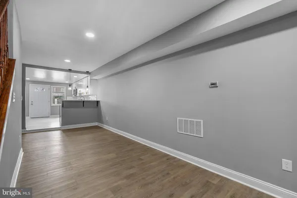 a view of empty room with wooden floor