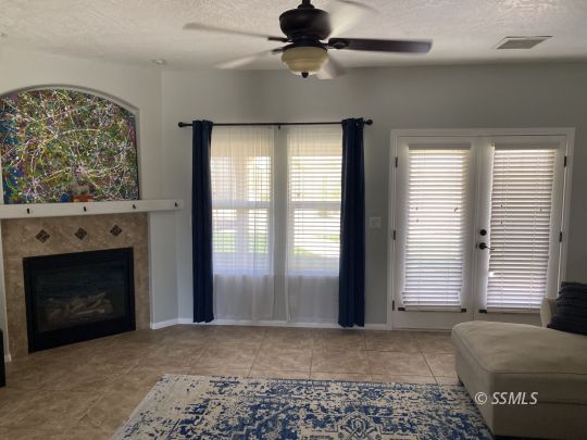 401 Acacia Street Ridgecrest, CA 93555 - Photo 10 of 42 a view of livingroom with window fireplace and ceiling fan