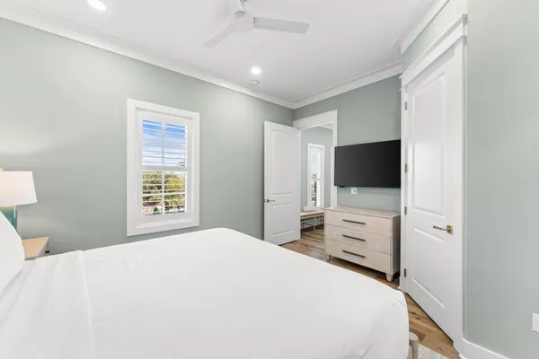 a bedroom with a bed and a flat tv screen on dresser