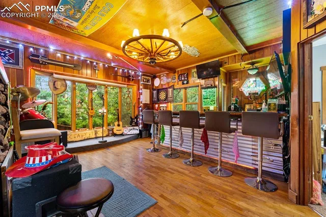 a living room with furniture floor to ceiling window and wooden floor