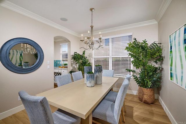 a dining room with furniture potted plants and wooden floor
