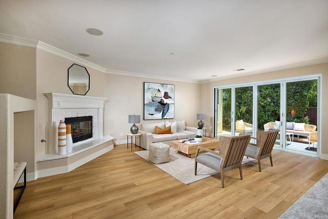 a living room with furniture a fireplace and a floor to ceiling window