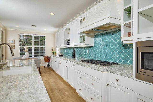 a kitchen with a stove a sink and a cabinets