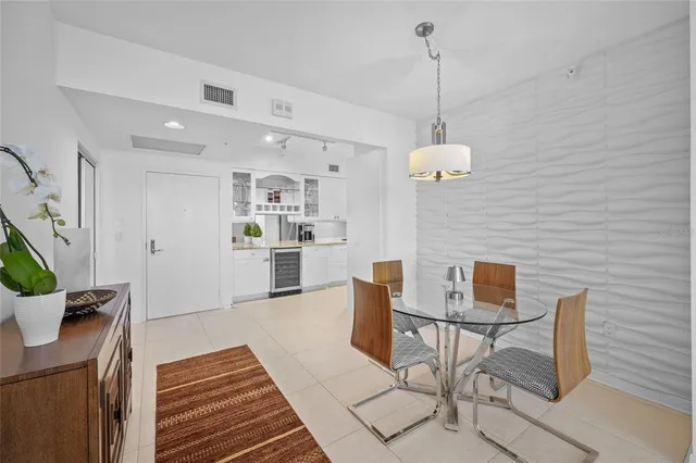 a kitchen with stainless steel appliances granite countertop a refrigerator a sink a stove and white cabinets with wooden floor