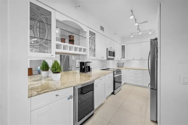 a kitchen with stainless steel appliances white cabinets and a stove top oven