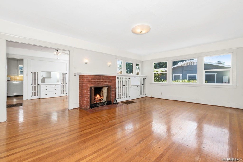 3023-3027 Olive Street San Diego, CA 92104 - Photo 23 of 41 Living room features original wood floors, built-ins, and a wood-burning fireplace