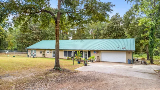a view of a house with backyard and a tree