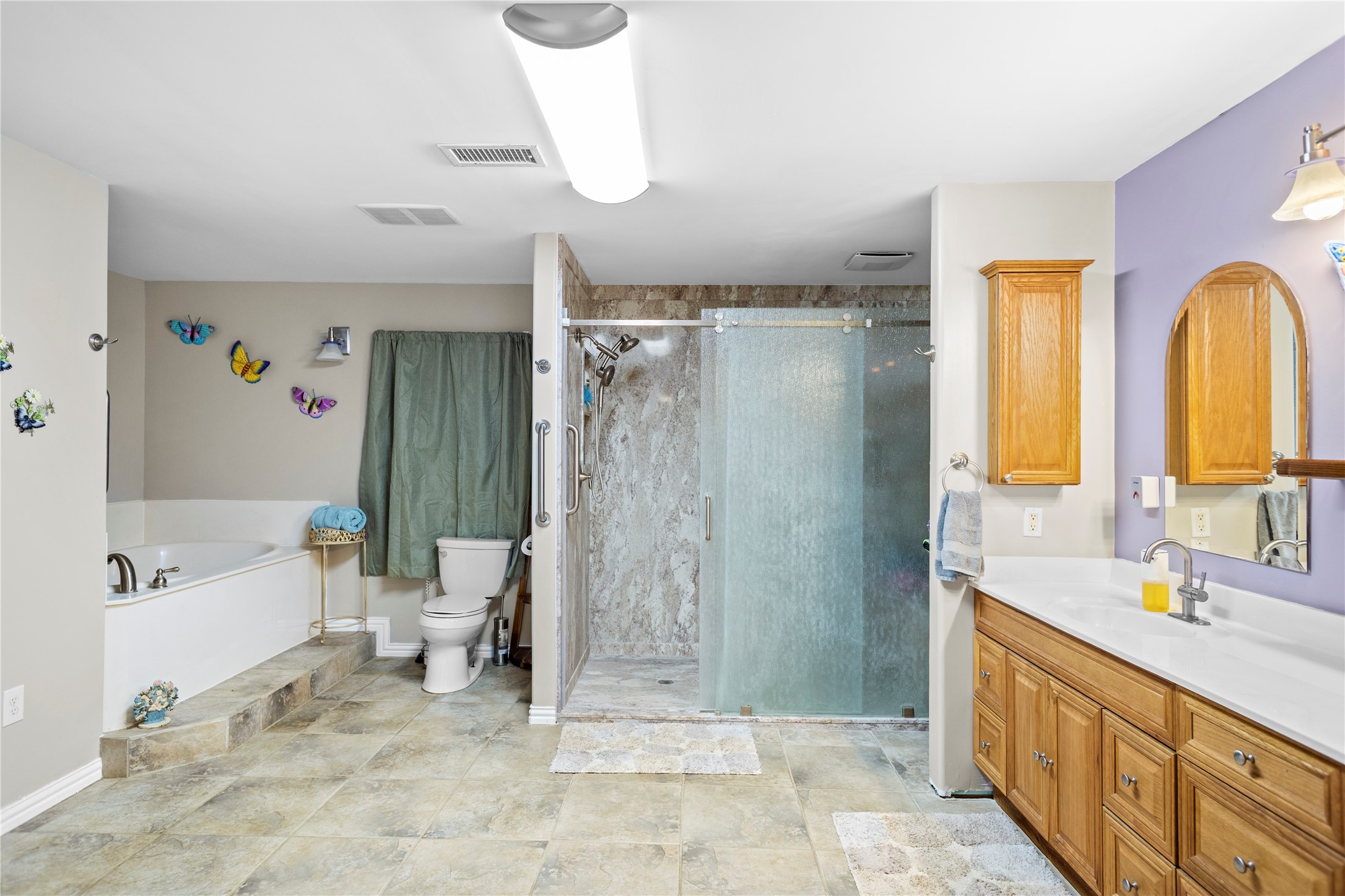 879 Interstate 45 Huntsville, TX 77340 - Photo 19 of 47 a spacious bathroom with a double vanity sink a mirror a bathtub and a shower