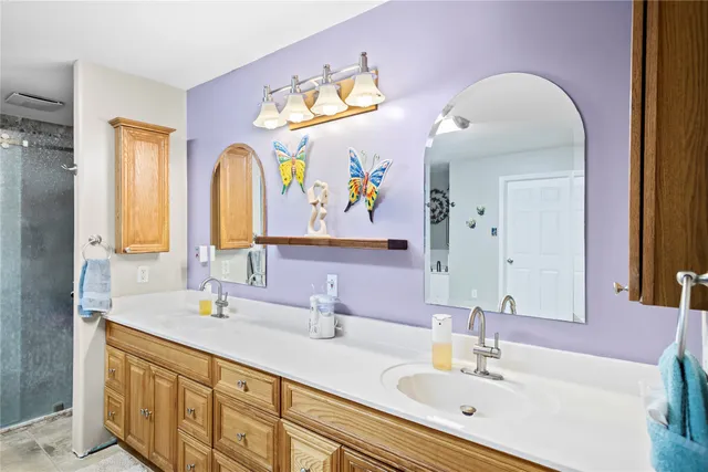 a bathroom with a double vanity sink and a mirror