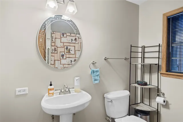 a bathroom with a toilet sink and mirror