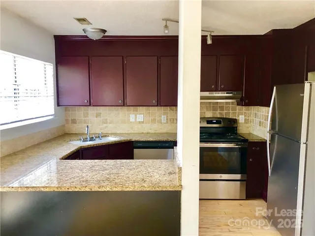 a kitchen with granite countertop a refrigerator and a stove