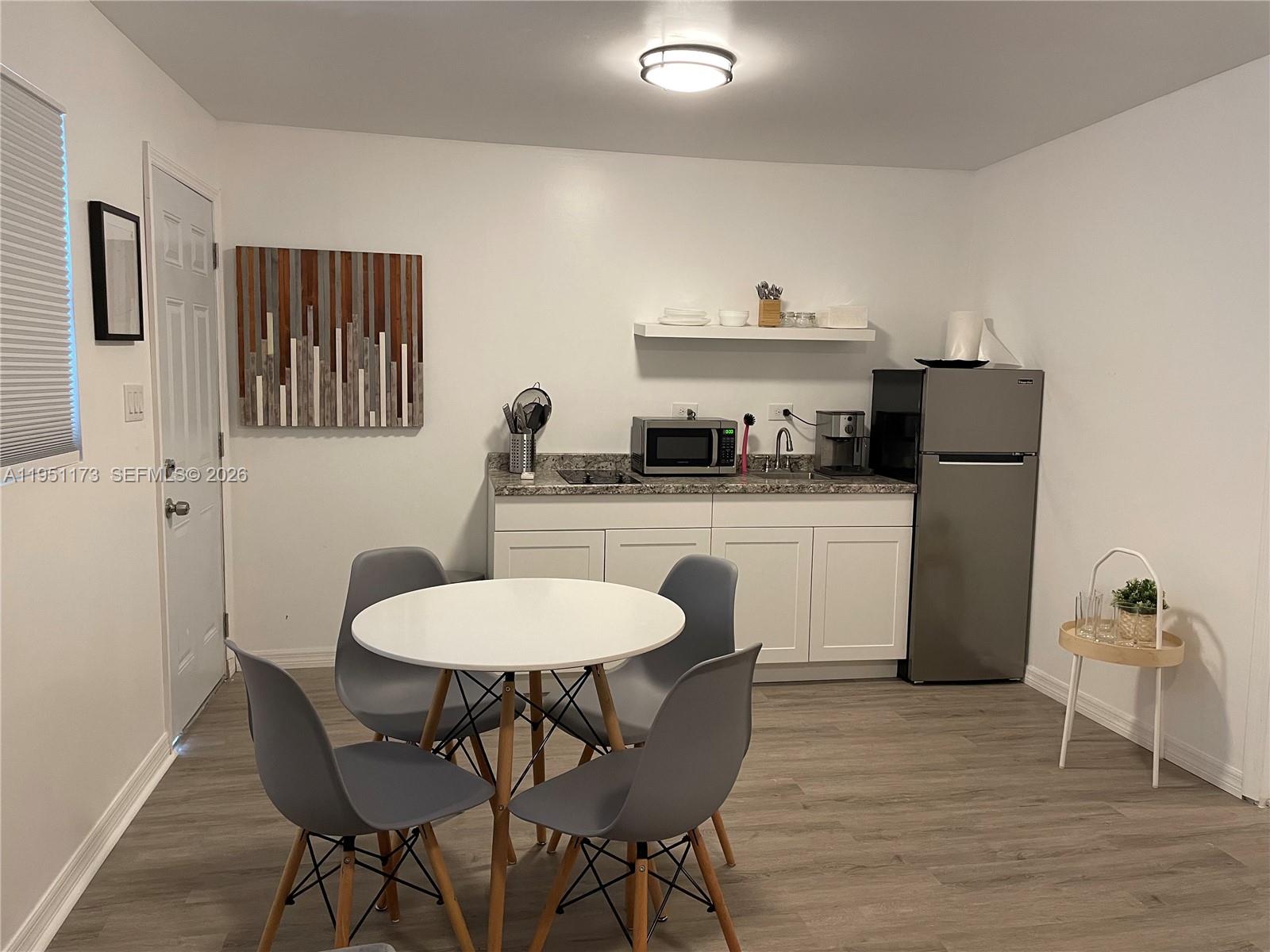2993 Southwest 16th Terrace Miami, FL 33145 - Photo 17 of 17 a kitchen with stainless steel appliances granite countertop a dining table chairs refrigerator and sink