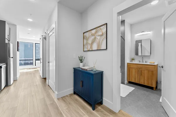 a view of bathroom with a sink mirror and window