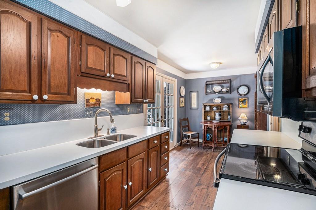 1484 Leafmore Place Decatur, GA 30033 - Photo 12 of 33 a kitchen with stainless steel appliances granite countertop a sink dishwasher stove and refrigerator with wooden floor