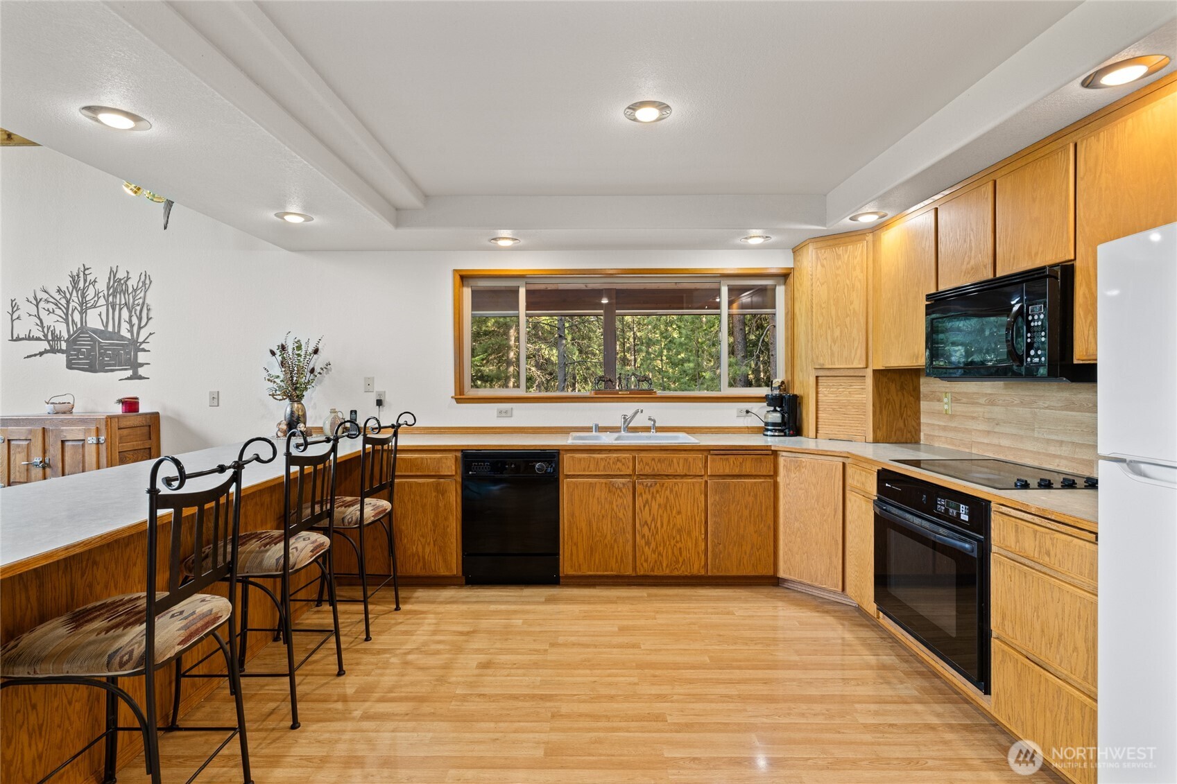 1101 Emerick Road Cle Elum, WA 98922 - Photo 19 of 40 a kitchen with stainless steel appliances granite countertop a stove top oven a sink dishwasher a dining table and chairs with wooden floor