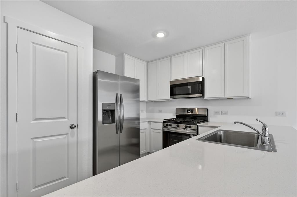 1516 Prince Road Howe, TX 75459 - Photo 8 of 28 a kitchen with a refrigerator a microwave a sink and cabinets