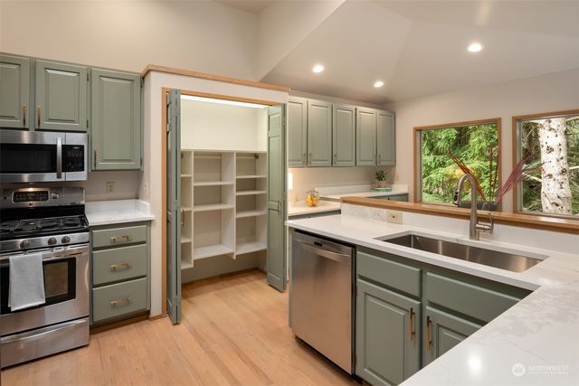 a kitchen with a sink stove top oven and cabinets