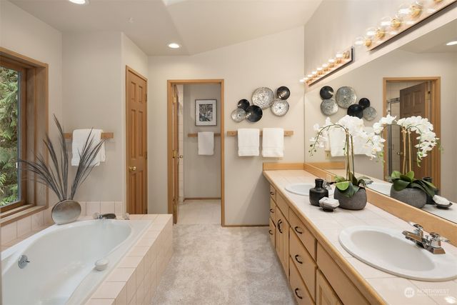 a bathroom with double vanity sinks a bathtub and a shower
