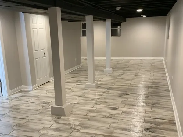 a view of an empty room with wooden floor and windows