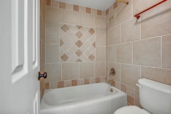 a bathroom with toilet next to a tub