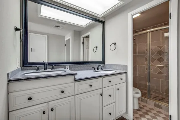 a bathroom with a granite countertop sink a toilet and a mirror