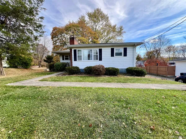a front view of a house with a garden and trees