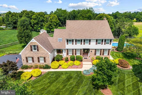 a front view of a house with garden and trees