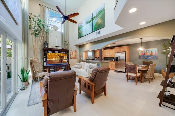 a living room with furniture a flat screen tv and kitchen view