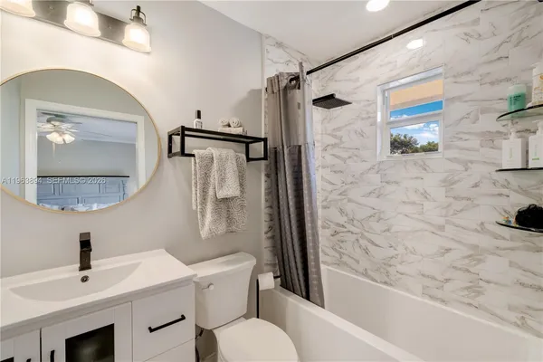 a bedroom with a bed and a flat tv screen on dresser