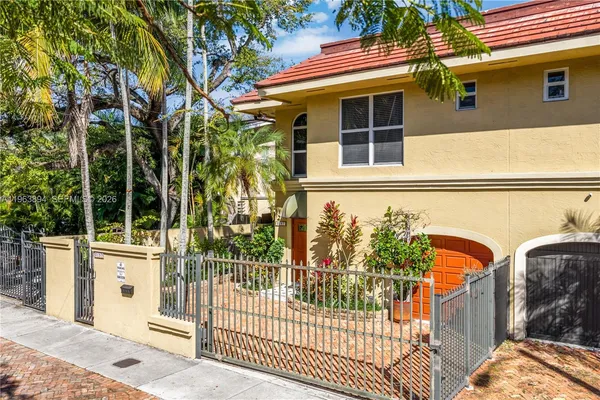 a front view of a house with a tree