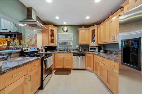 an open kitchen with stainless steel appliances granite countertop a stove sink and cabinets