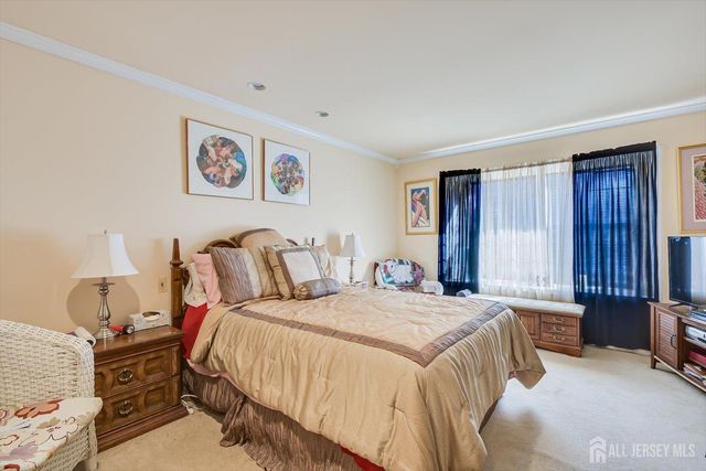 a spacious bedroom with a bed a couch and dresser